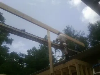 Carpenter setting a ridge beam over a new addition frame — Ice Dam Removal by Roofing Brothers in Slate Hill