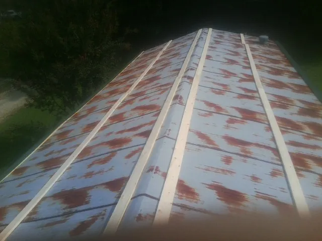 Rusted metal roof panels with new wood purlins before replacement — Storm Damage Roof Repair in Slate Hill by Roofing Brothers