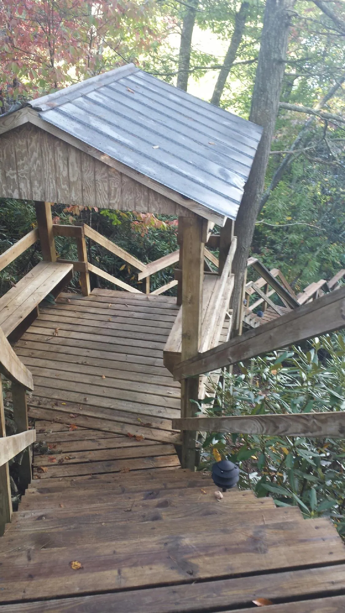 Metal roofed shelter over wooden steps on a wooded walkway — Skylight Repair & Installation work by our crew in Slate Hill