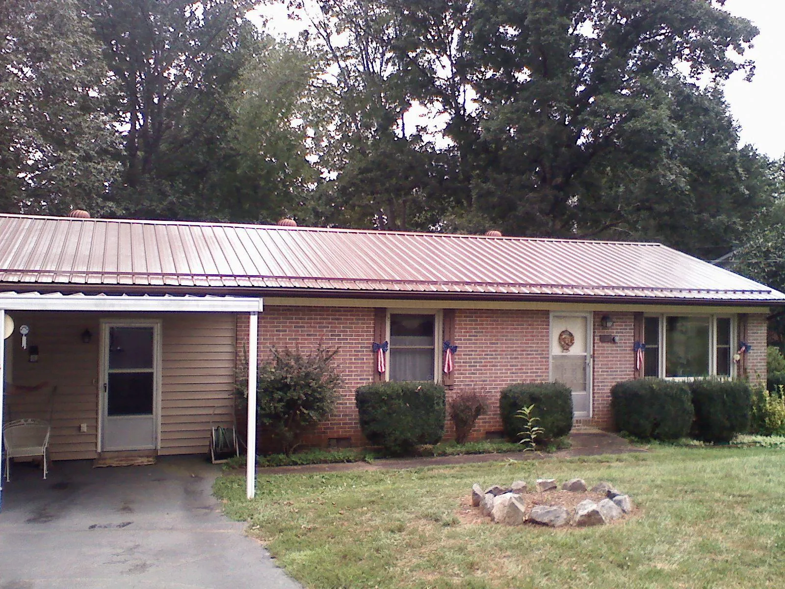 Bronze metal roof and carport on a brick ranch home — Roof Repair work by our crew in Slate Hill
